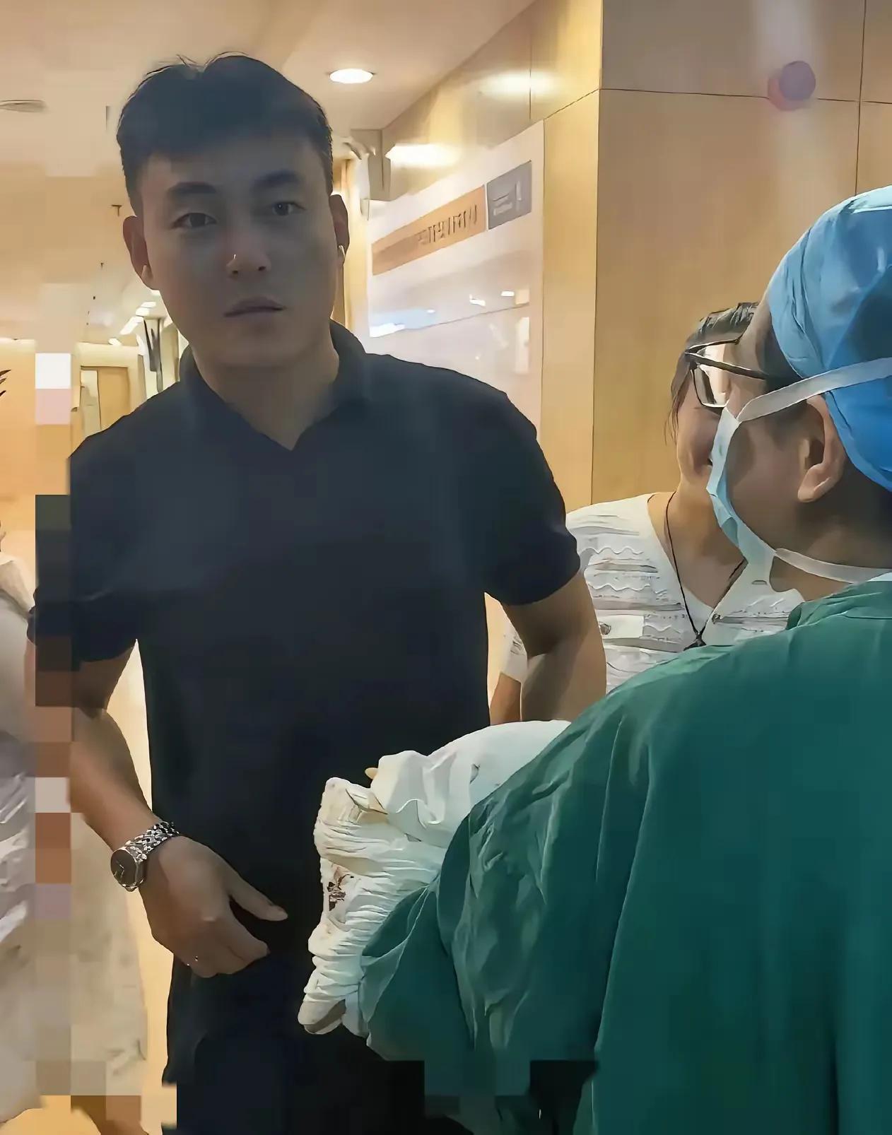 护士抱着刚出生的宝宝从产房里出来，见到孩子爸爸后，护士让他猜猜是男孩还是女孩，爸