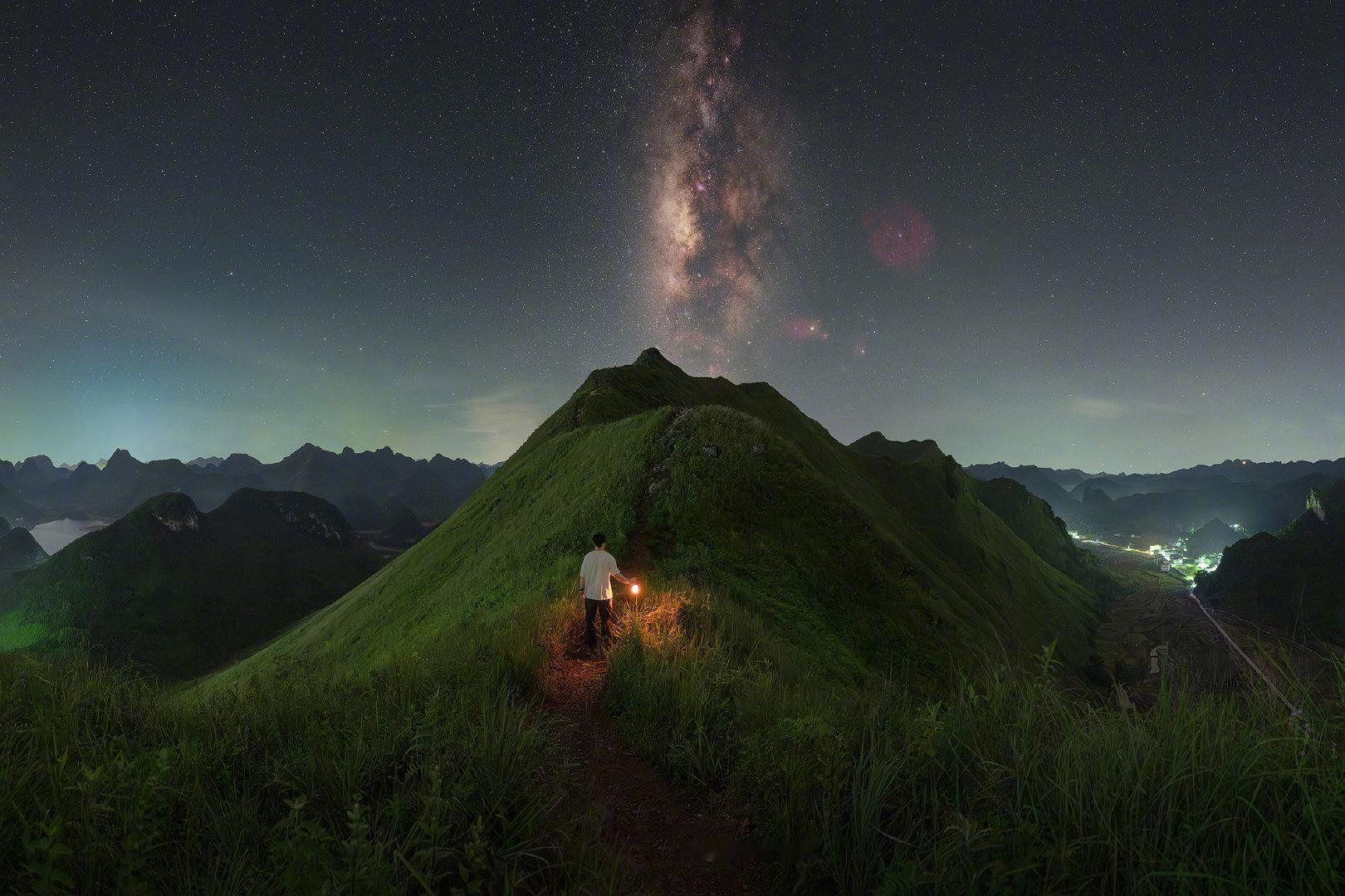 群山在夜里悄悄沉入静默，只有山脊线保留着锋芒。银河自高处垂落，如一条古老的河流。