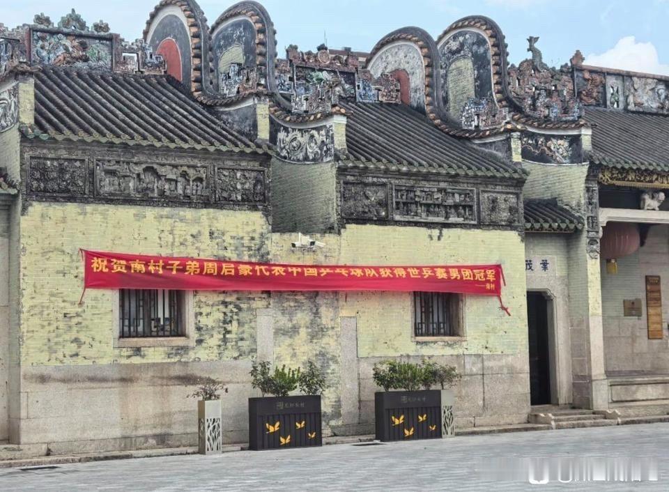 家乡拉个横幅，单独祝贺周启豪赢得世乒赛男团冠军。
上面写着“代表中国乒乓球队获得