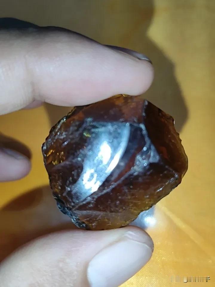 江水退落，江边常见的一枚玻璃质碎块。
标本具备典型贝壳状熔融断口，呈通透棕褐色。