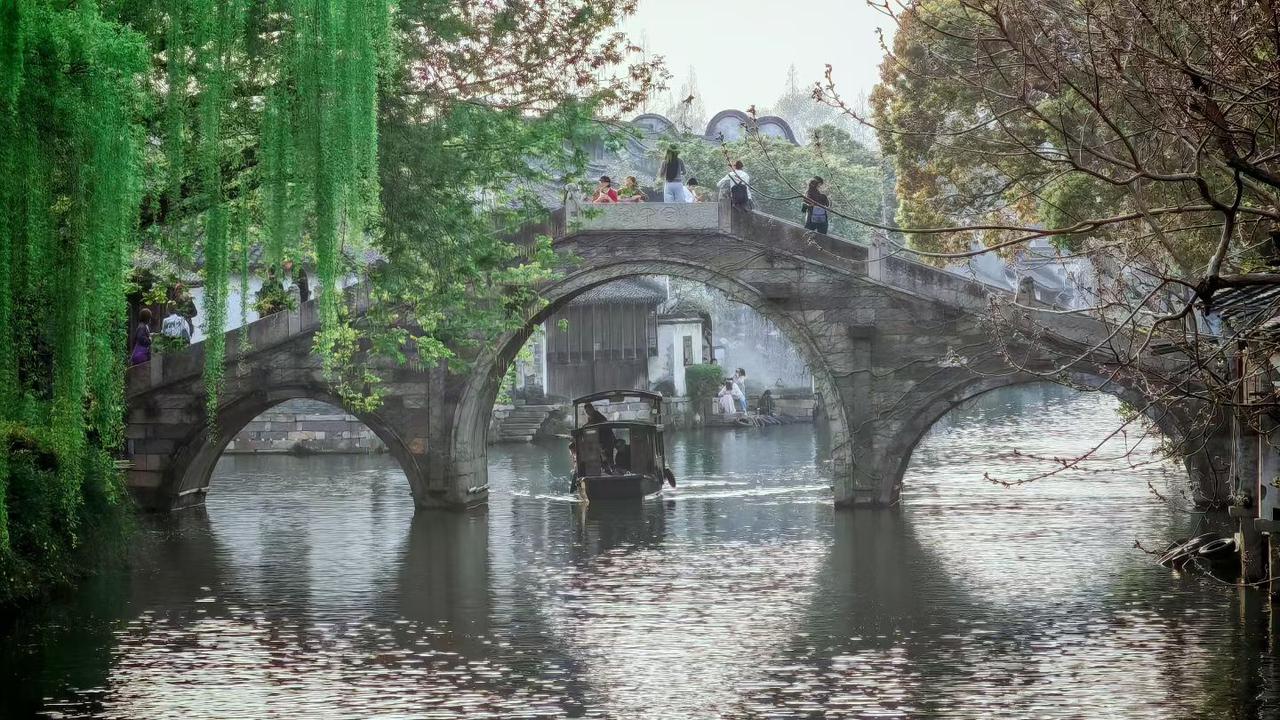 垂柳如烟笼古桥，画船轻摇破春
青石板上载流年，白墙黛瓦入画来。风拂柳丝软，水漾涟