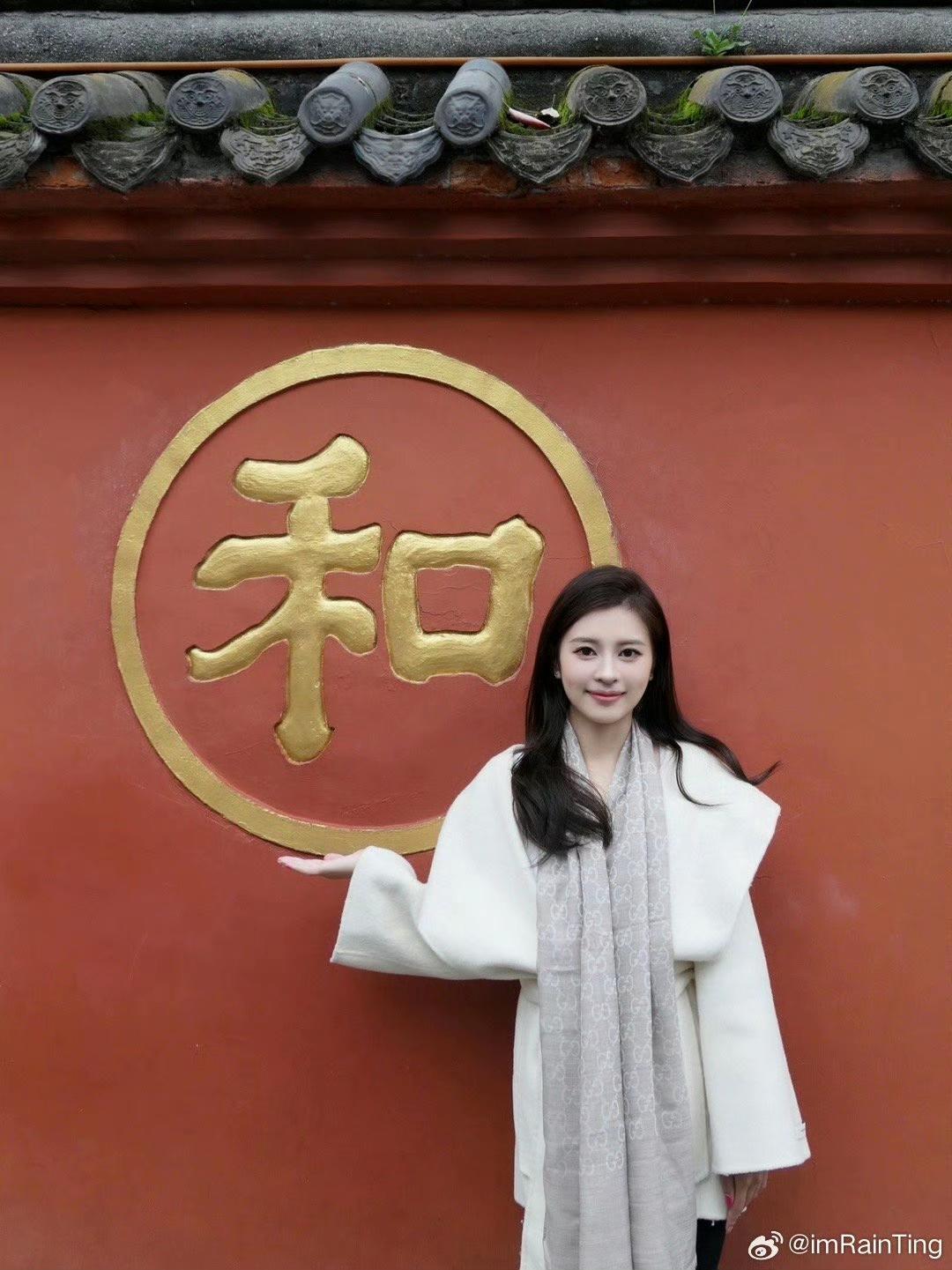 这姑娘站在“和”字墙前拍照。