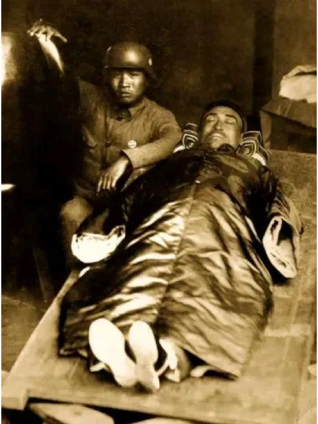 淞沪会战，杨杰将军的最后遗容。照片中杨杰将军躺在一块木板上，头上戴着帽...