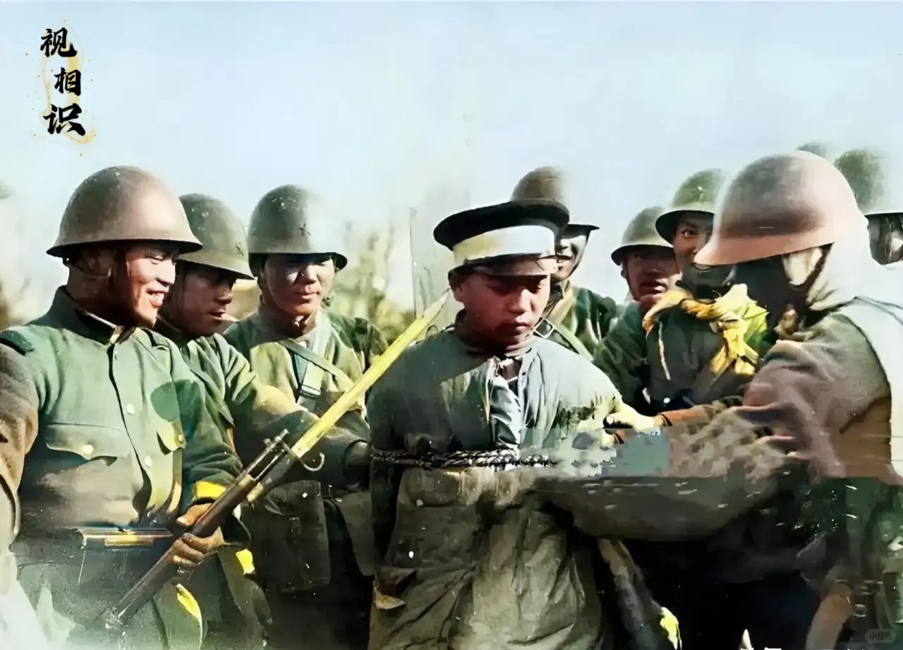 1931年，沈阳城沦陷后，一名年轻的警察正被日军绑缚的场景，镜头中左边的日寇举着...