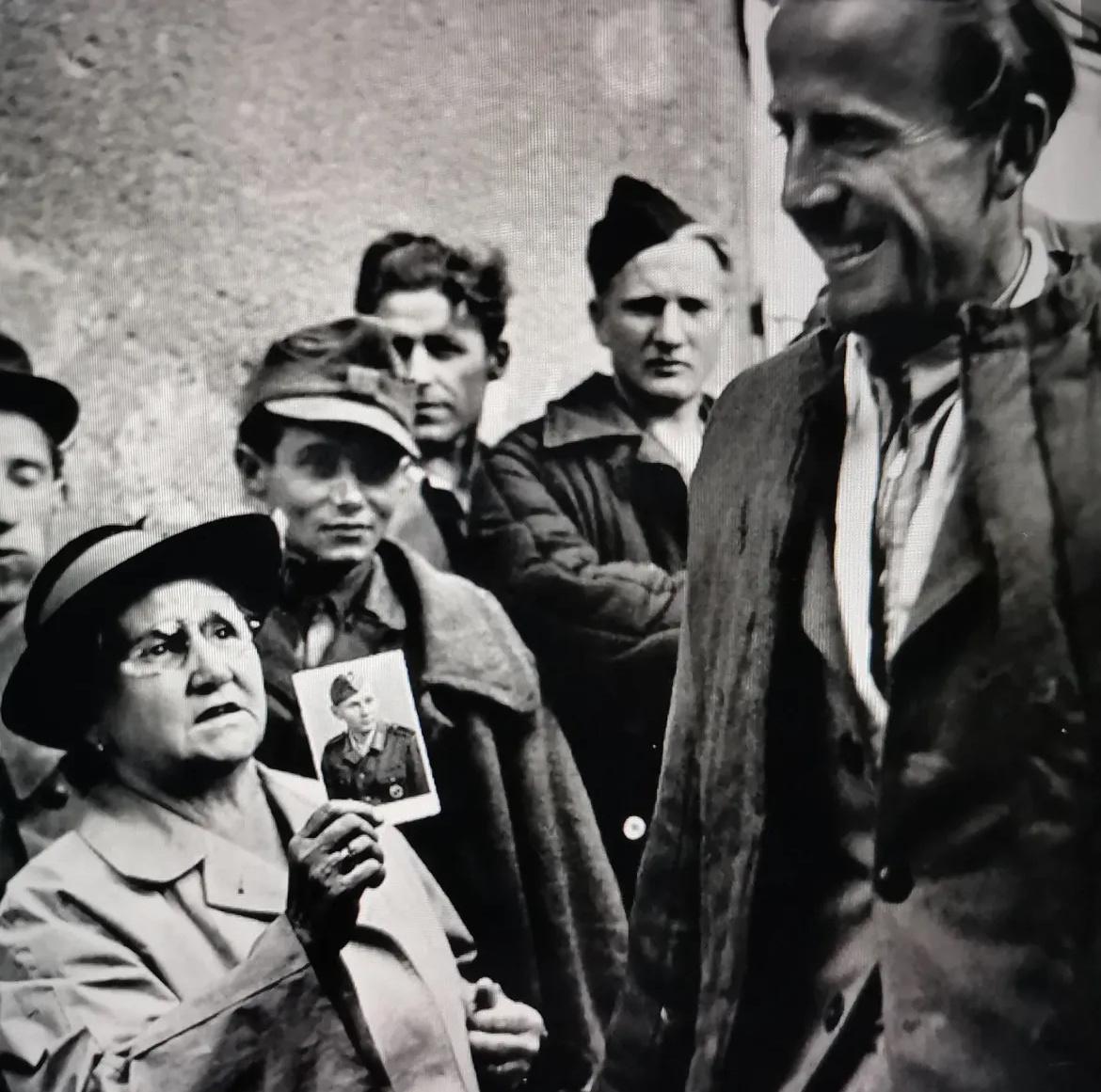 【来自投稿】1947年 维也纳火车站，一位母亲手持儿子参军时的照片，向每一个下车