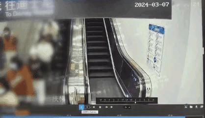 上海。
男子在地铁站乘扶梯上行，女子从其左侧快速通行，撞在男子左臂致其手机掉落，