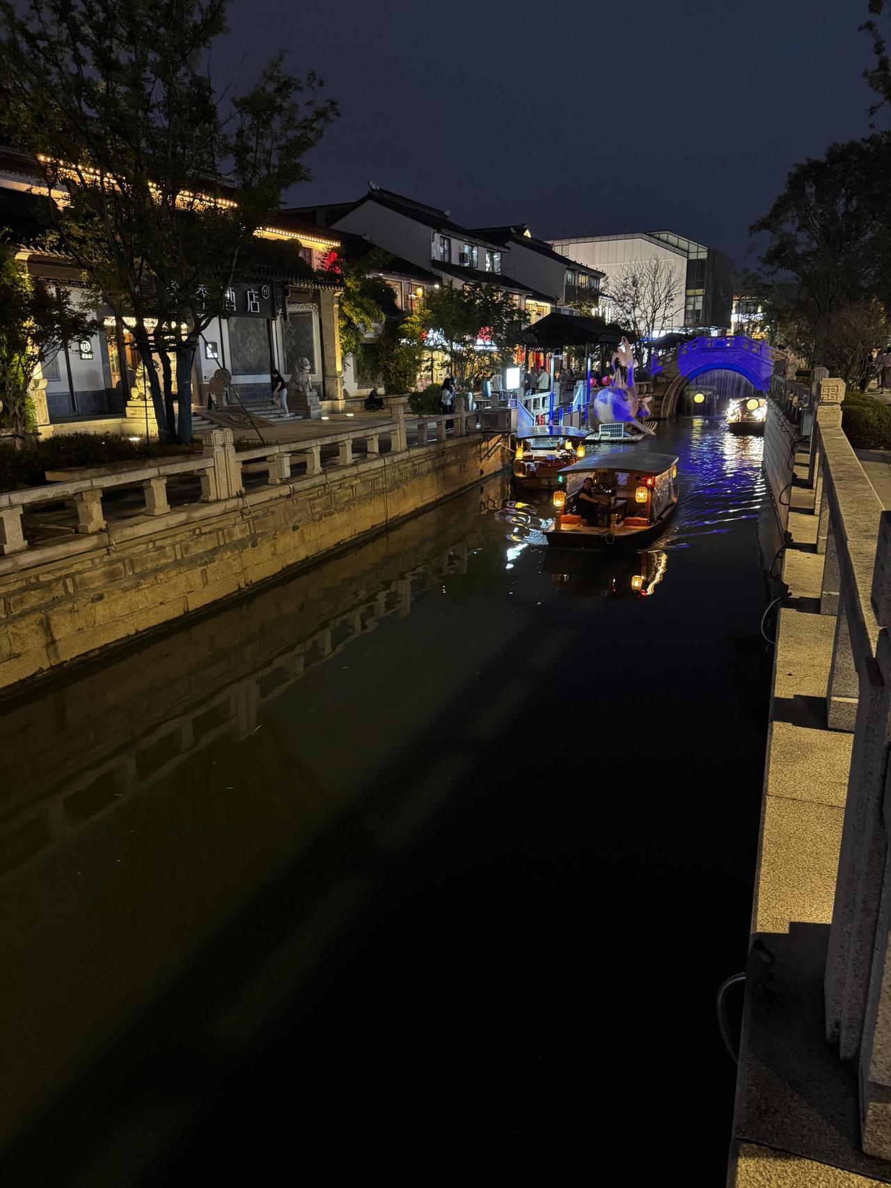 夜色下的江南水巷，灯火倒映河面，摇橹船缓缓穿行，晚风裹挟着市井烟火，感受独属于苏