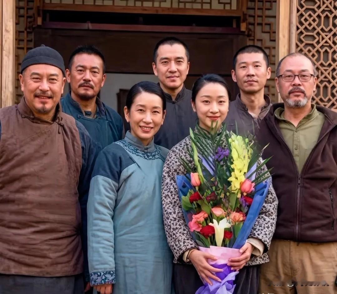 7位演员合影照。张嘉译、秦海璐你可能一眼就认出来，而抱鲜花的美女你真还不一定。她