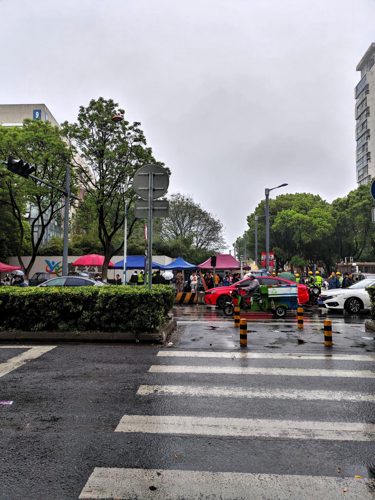 雨天路口这一幕真的太暖了！

帐篷下排队的人、雨里值守的交警，还有穿梭的车流，都