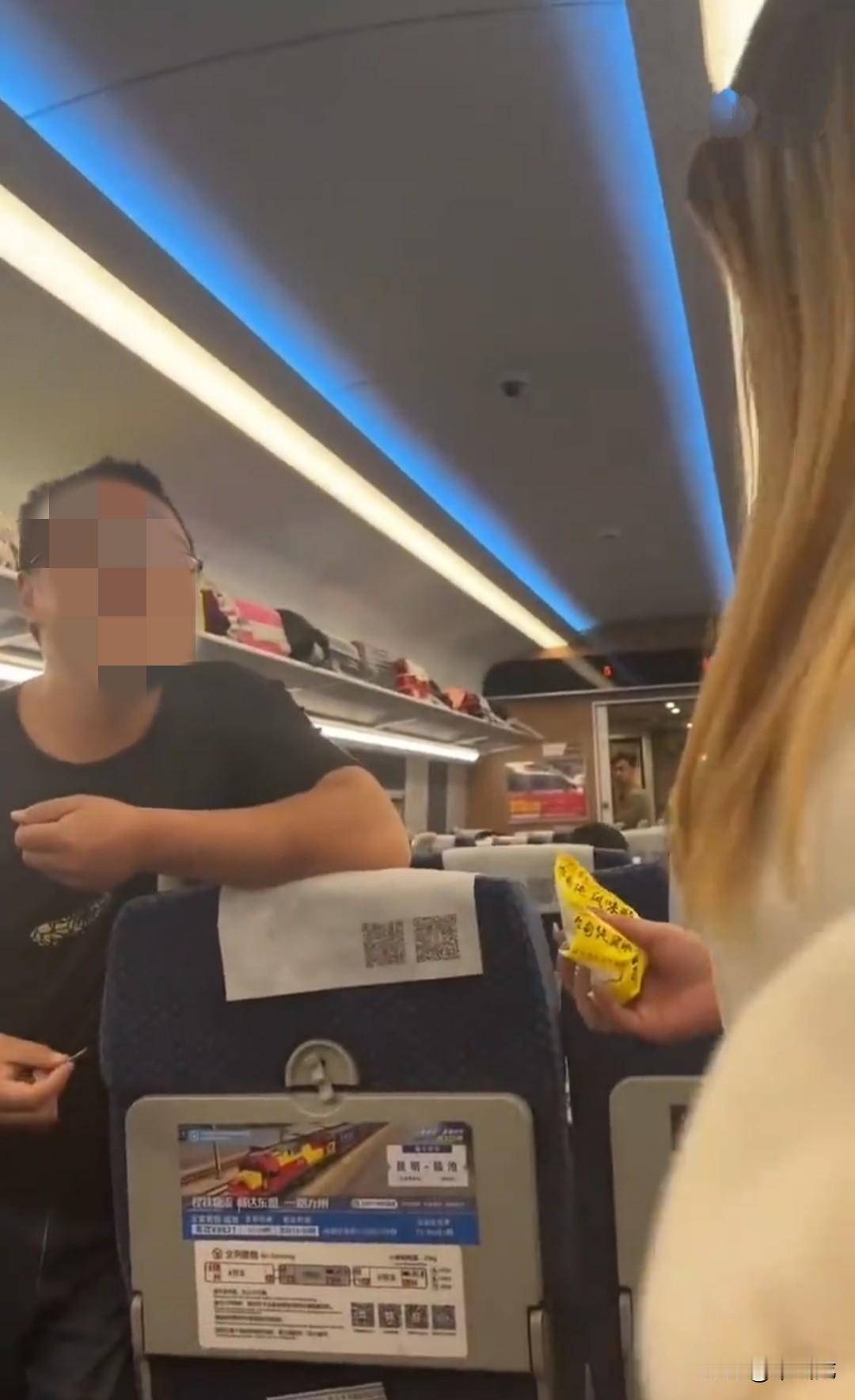 两名女子在动车上指责前排小孩太过吵闹，大人也不管管。
小孩父亲直接走过来，倚靠着