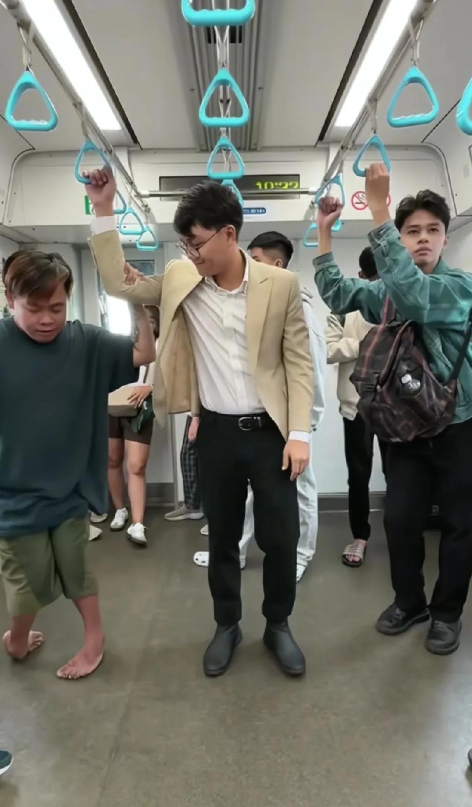 地铁上，残疾小伙子有些费劲地拉着吊环，站在旁边的陌生男子看了看后，突然伸出了一只