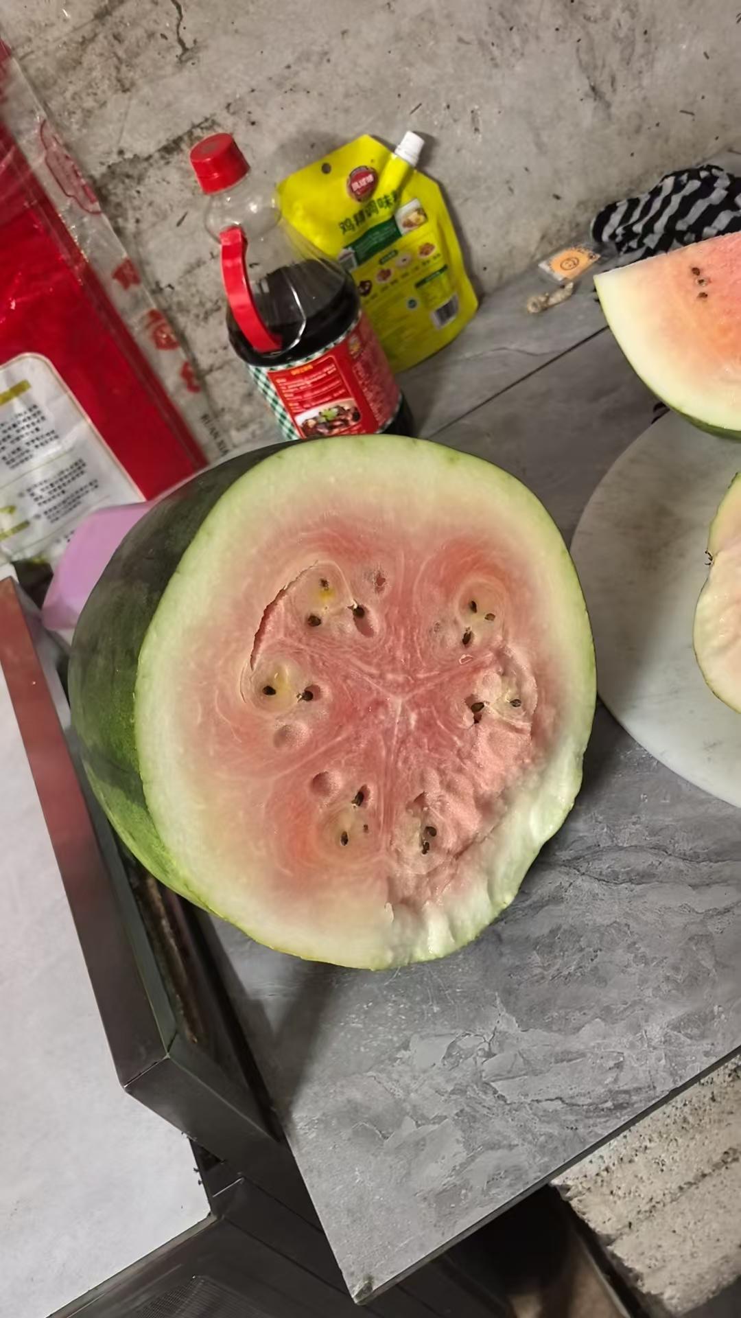 昨天帅哥从老家带了两个大西瓜到广东来。
今天婆婆打开一个，竟然长这样，还是白色的