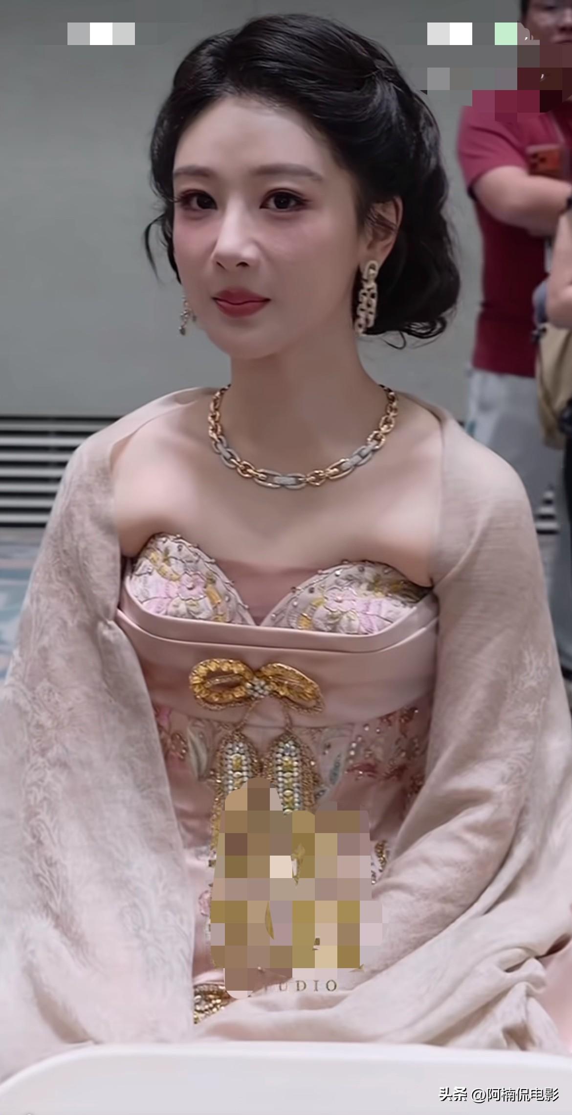 杨紫白玉兰这套国风刺绣礼服站着时堪称温婉绝色，浅粉缎面搭配花卉钉珠，金色蝴蝶结点