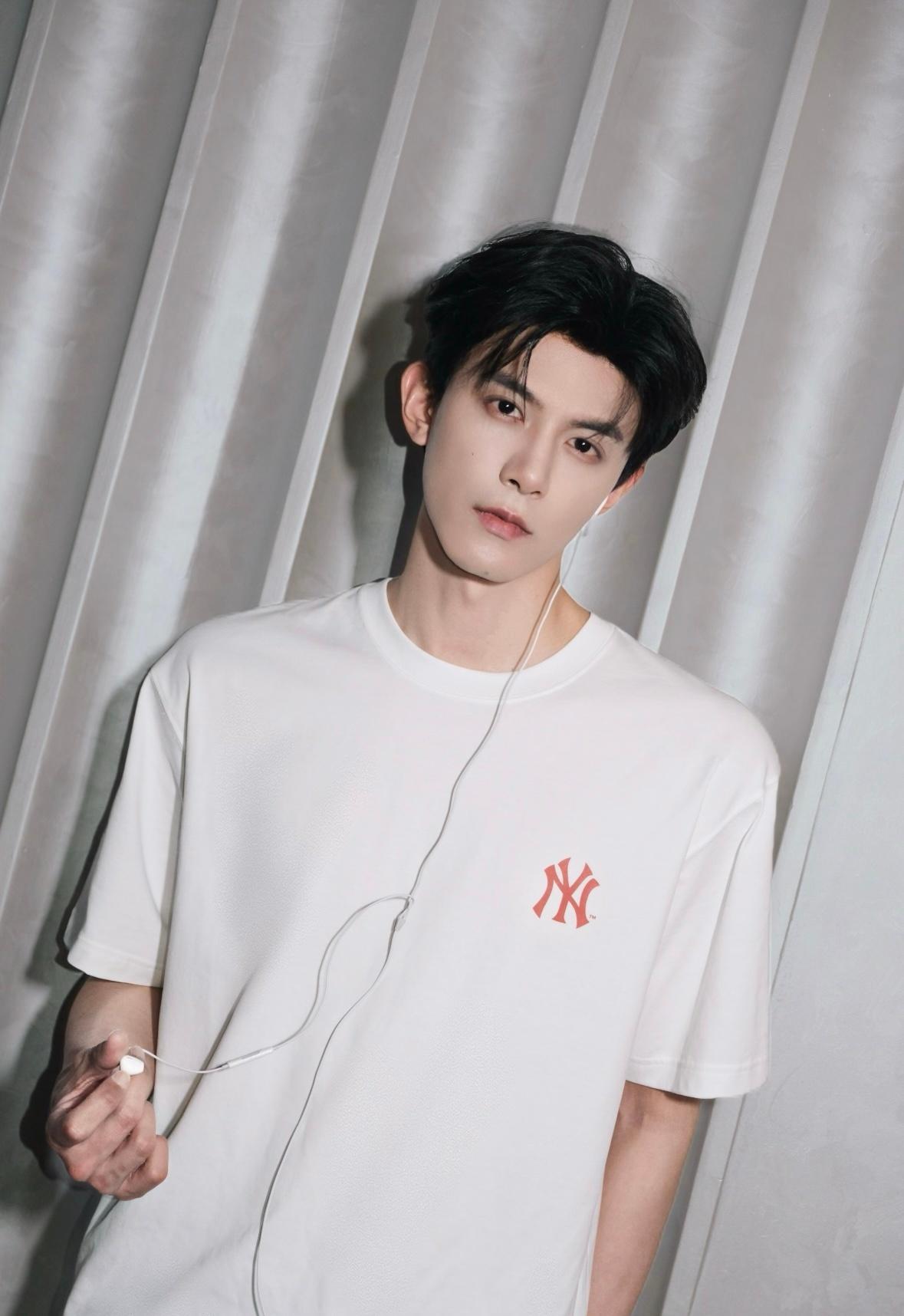 邓凯又又又拍照了！浪漫的有线耳机，简单的白色MLB印花T恤，温柔松弛，帅得很轻松