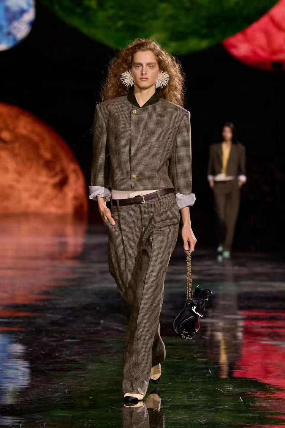 权志龙GD今日启程巴黎，受邀出席当地慈善活动。醒目的红色方格围巾搭配黑色长款外套