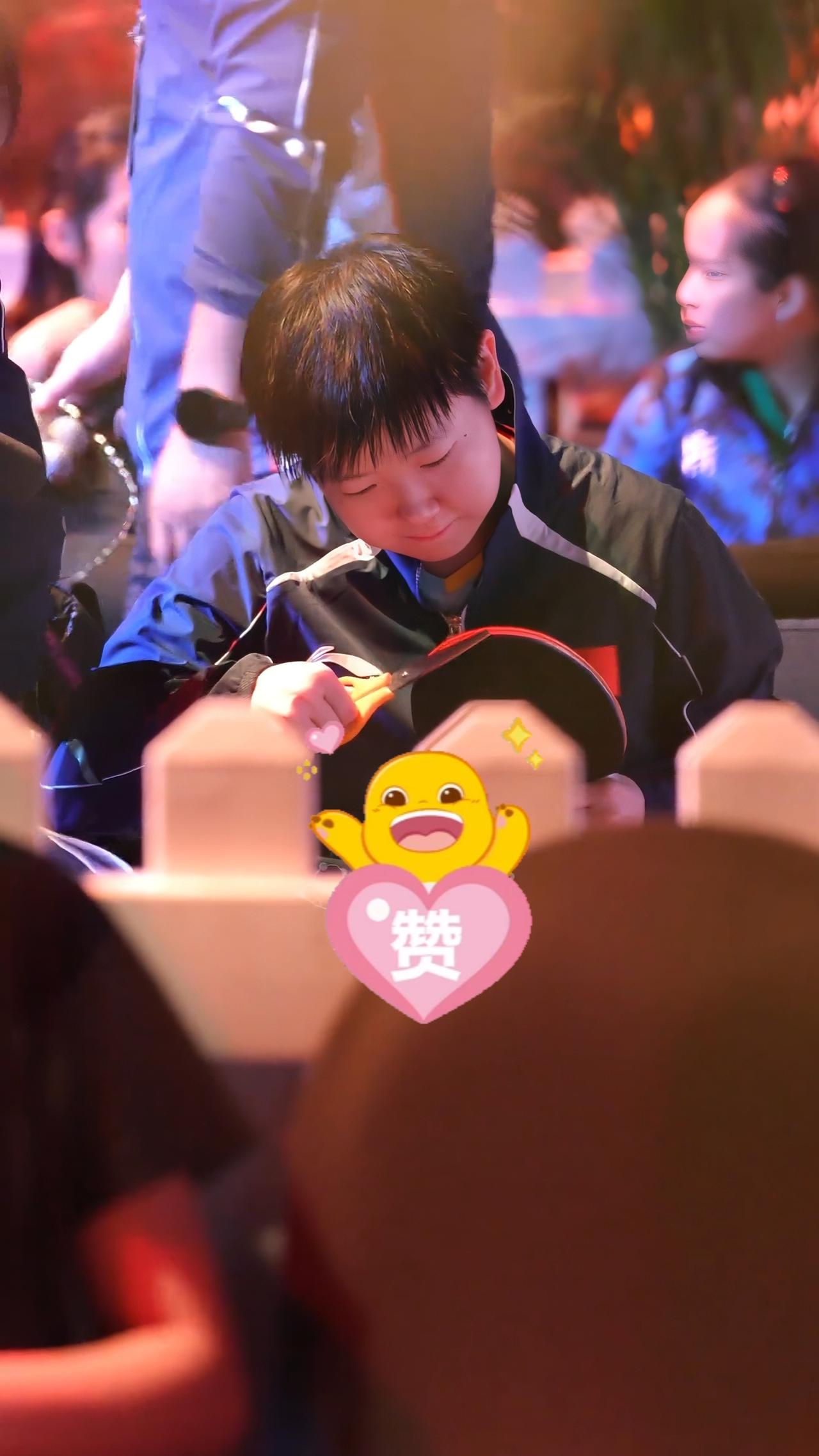 没想到，
也能看到孙颖莎修剪胶皮的认真样子，
这要感谢田点圈子，
是她在新加坡大