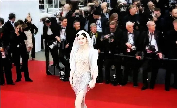 红毯上，保安架着人往外拖，那姑娘的裙摆还在闪光灯下拼命挣扎。
国际直播镜头里，这