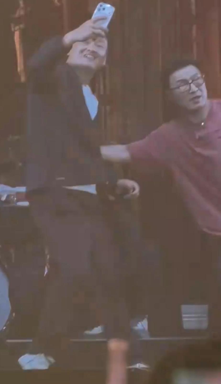 一名男粉丝冲上舞台想和汪峰合照，刚拿出手机没想到被汪峰一把推开，男粉丝站在原地尴