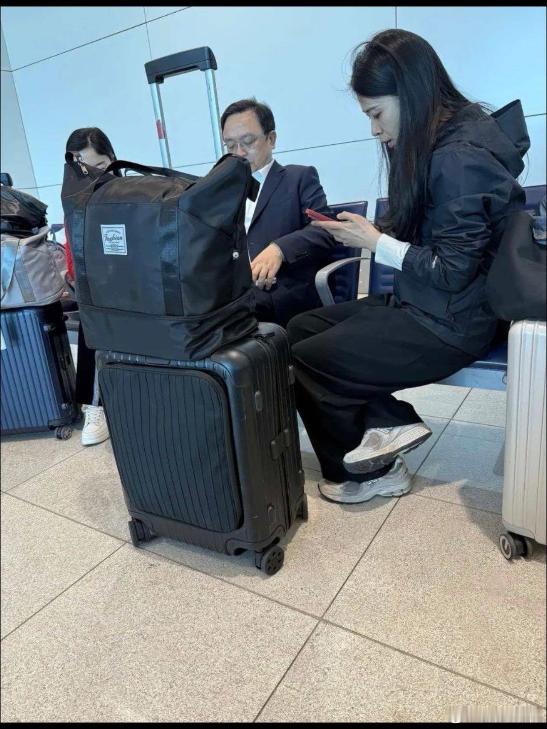 网友拍到的船夫哥在机场普通候机厅，旁边秘书鞋子也是沾灰的运动鞋。 