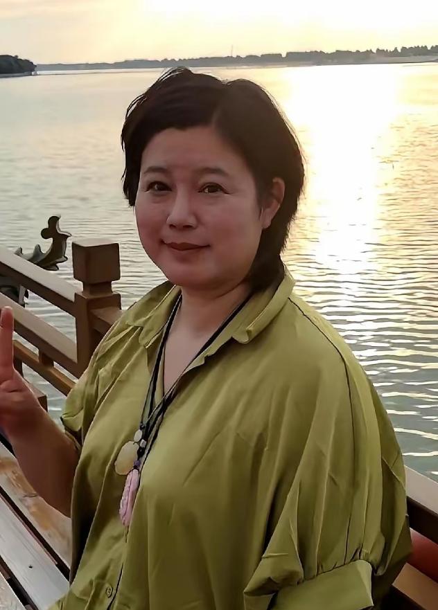 要不是有人提醒，怎么也不敢相信。眼前这个短发、眯着眼睛笑、双下巴都很明显的大姐，