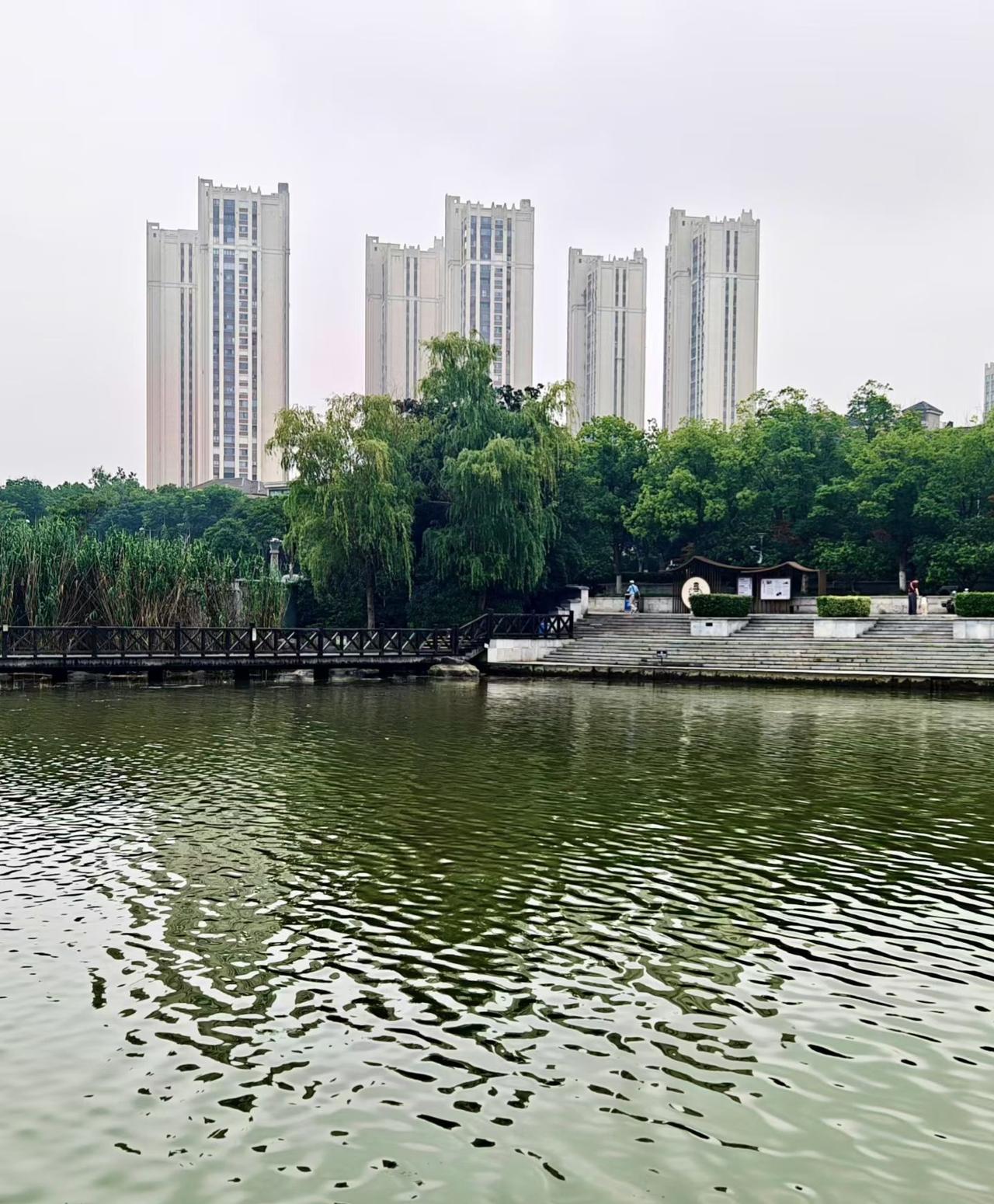 ​
2. 湖水荡漾，林木葱郁，临水长廊往来行人。城市一隅的湖山景致，藏着难得的悠