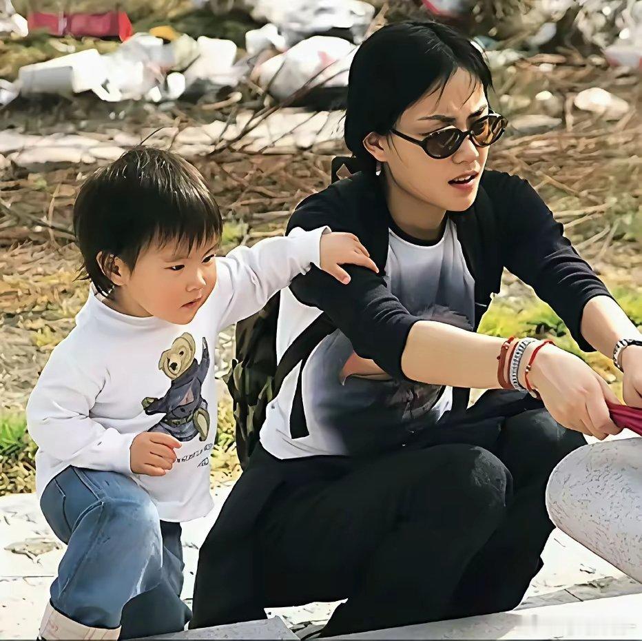 年轻时的王菲带着女儿窦靖童回到上海在母亲的墓前祭拜时的一幕 