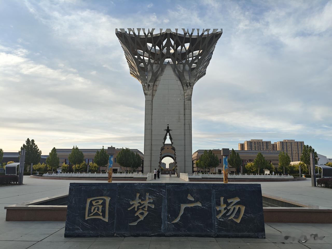 菩萨蛮·金塔圆梦广场
       银雕轻刺云光远，穹痕斜曳新程浅。石案载风长，