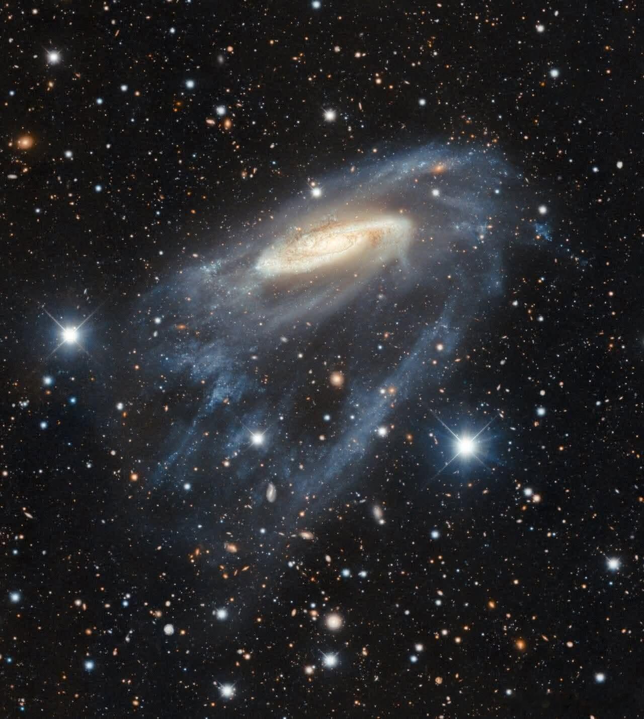 凝视NGC 3981——一个螺旋星系，其旋臂在虚空之中以狂野、不规则的图案扭曲和