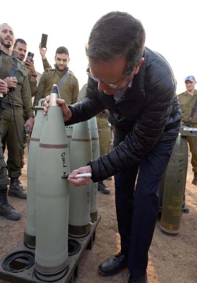 犹太总统赫尔佐格在视察加沙地带北部的一个炮兵营时，在一枚将用于轰炸加沙的炮弹上签