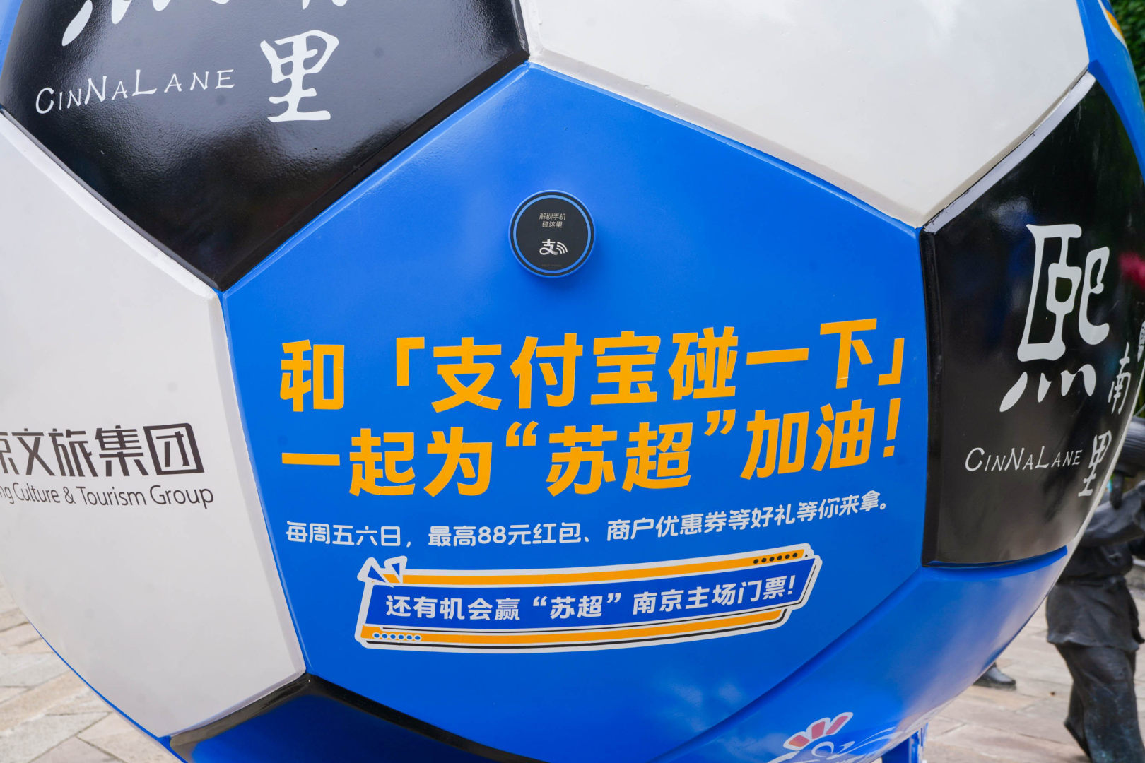 百店发支付宝助威袋为南京队加油打卡熙南里足球趣味现场，体验射门与寻宝项目，为南京