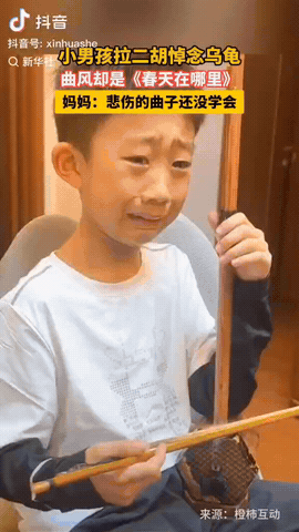 辽宁沈阳，一男孩家的小乌龟死了，他拉二胡悼念，脸上满是悲伤，眼里噙着泪水，可拉的