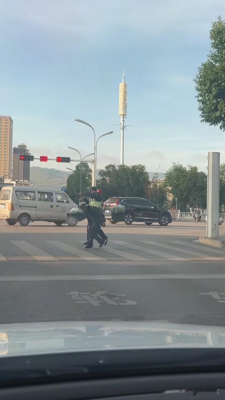 瞧瞧咱云南玉溪江川的交警，看到一老爷爷扛着扁担过马路，交警叔叔二话不说，将扁担“