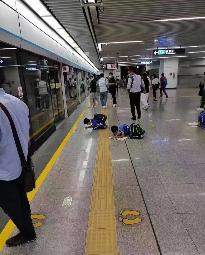 应试教育下的悲哀----深圳地铁站孩子趴在地上写作业 ​​​