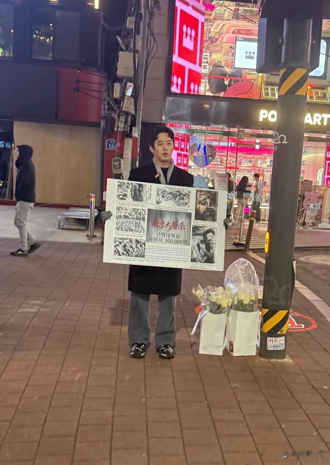 韩国街头这个男子，是个非常有正义感的人，他举着牌子，站在街头，用这种直接的方式，