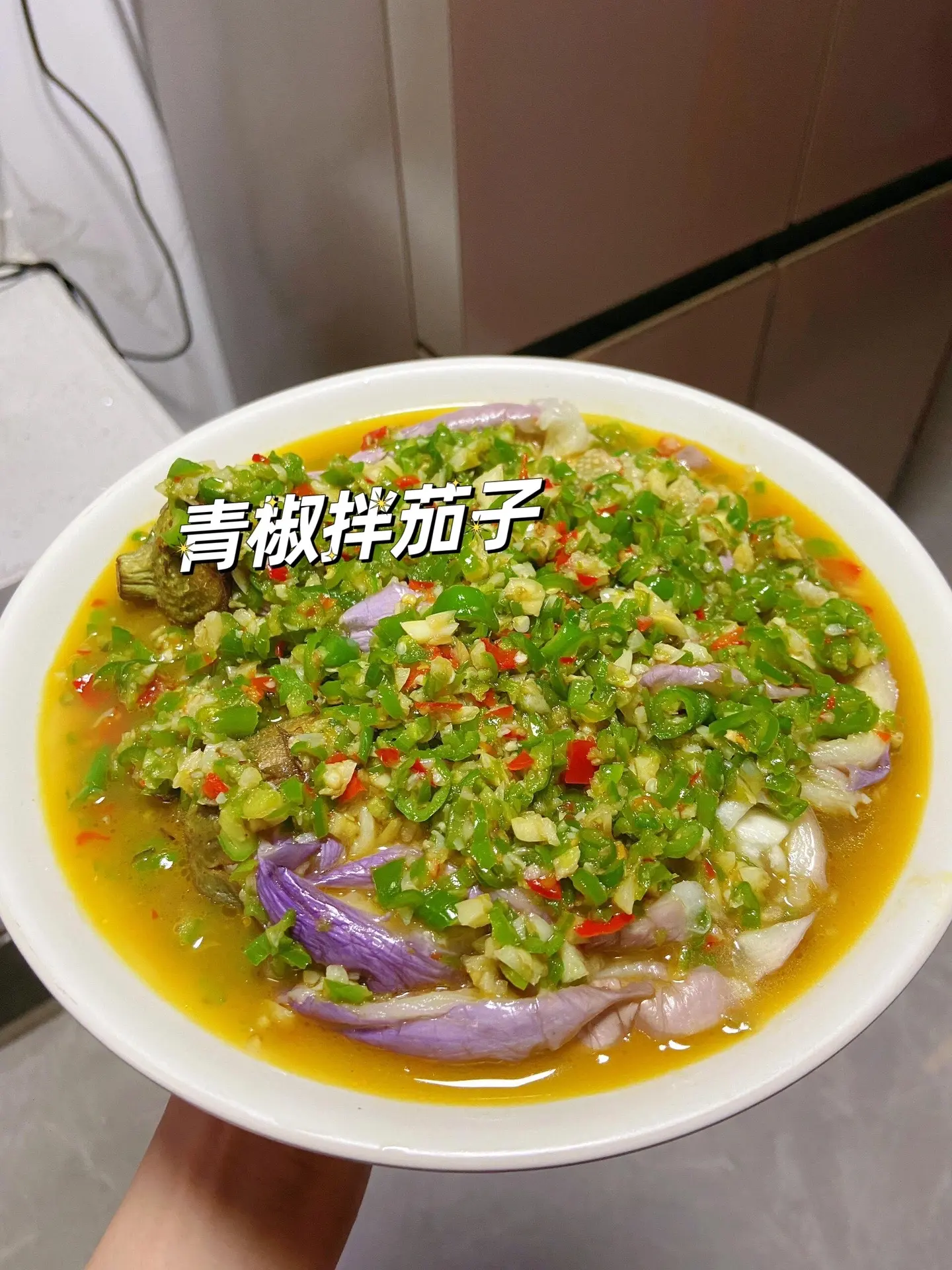 非常好吃又下饭的青椒拌茄子。青椒和茄子的清香加上蒜香，软糯入味，真的太下饭了！
而且还不油腻，很适合夏天，好吃叉开胃！
不太能吃辣的话用线椒，能吃辣用螺丝椒。
做法
1⃣️青椒 红辣椒 切碎，一头蒜剁碎。
2⃣️锅烧油，炒香蒜末和辣椒，加一碗水煮沸，盐 蚝油鸡精调味。
3⃣️茄子水开上锅蒸熟，撕成条，淋上辣椒酱汁即可。