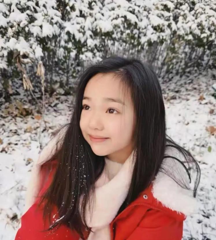 董璇分享了女儿小酒窝的初雪美照，照片里小酒窝穿着红色羽绒服，在雪地里尽情撒欢，活