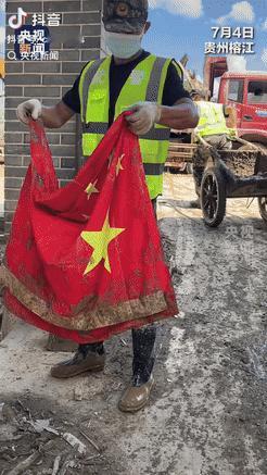 贵州榕江，一位武警战士在清理淤泥时，意外发现一面国旗，他立刻小心地将其捡起，清洗