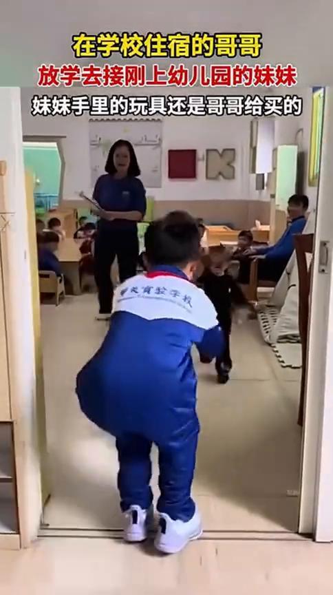 在学校住宿的哥哥放学去接刚上幼儿园的妹妹，妹妹手里的玩具还是哥哥给买的。