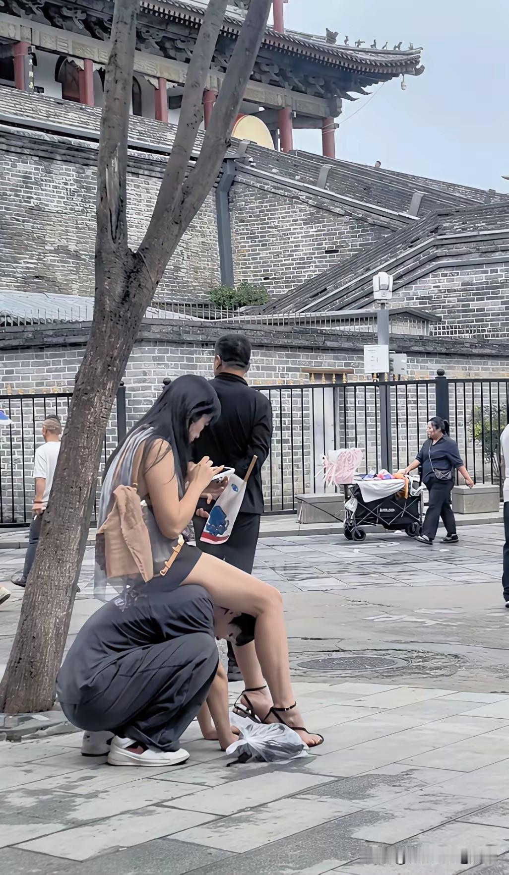 看到这张图片我气的肝疼，一个男孩蹲在地上，两手扶地，一名女子泰然自若地坐在男孩身