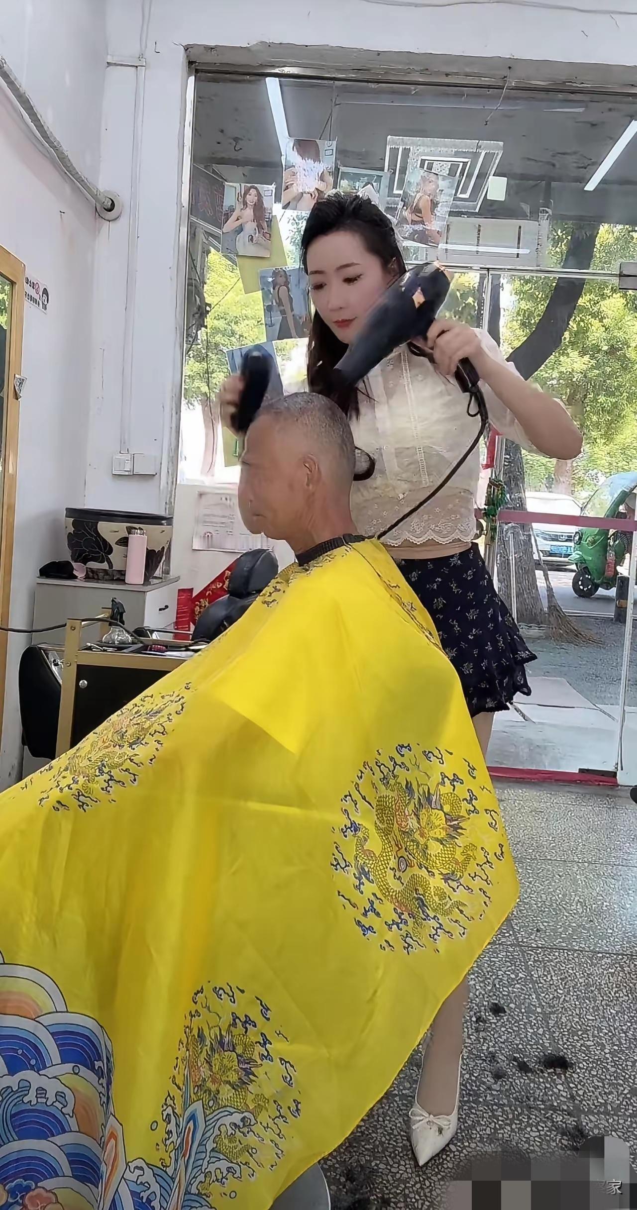 大爷剪发披上“龙袍”，理发师手持吹风机当“玉玺”，一吹一梳全是“奉天承运”！这哪