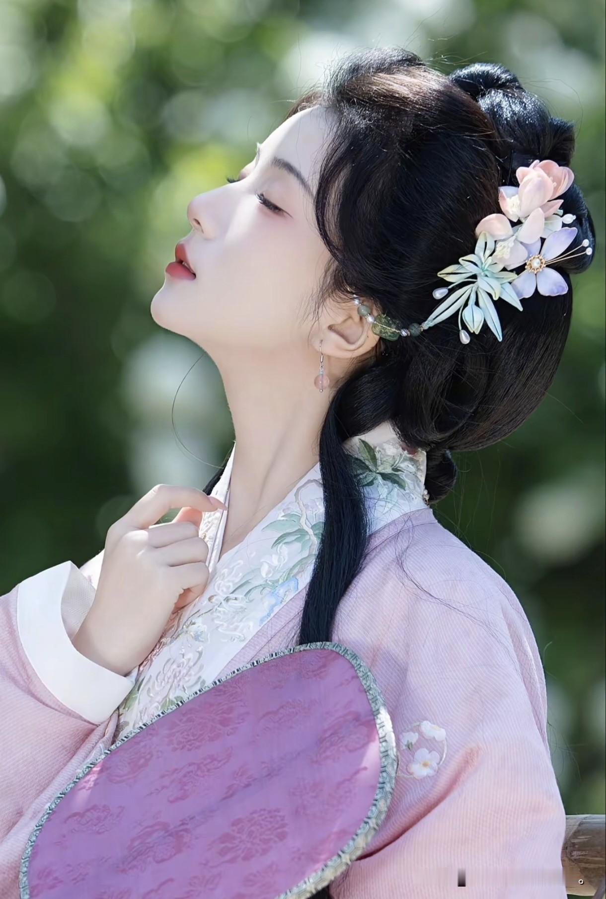 像是从山水画里走出的仙子。
身畔是碧波荡漾的江水，
身后是连绵起伏的青山。
不需