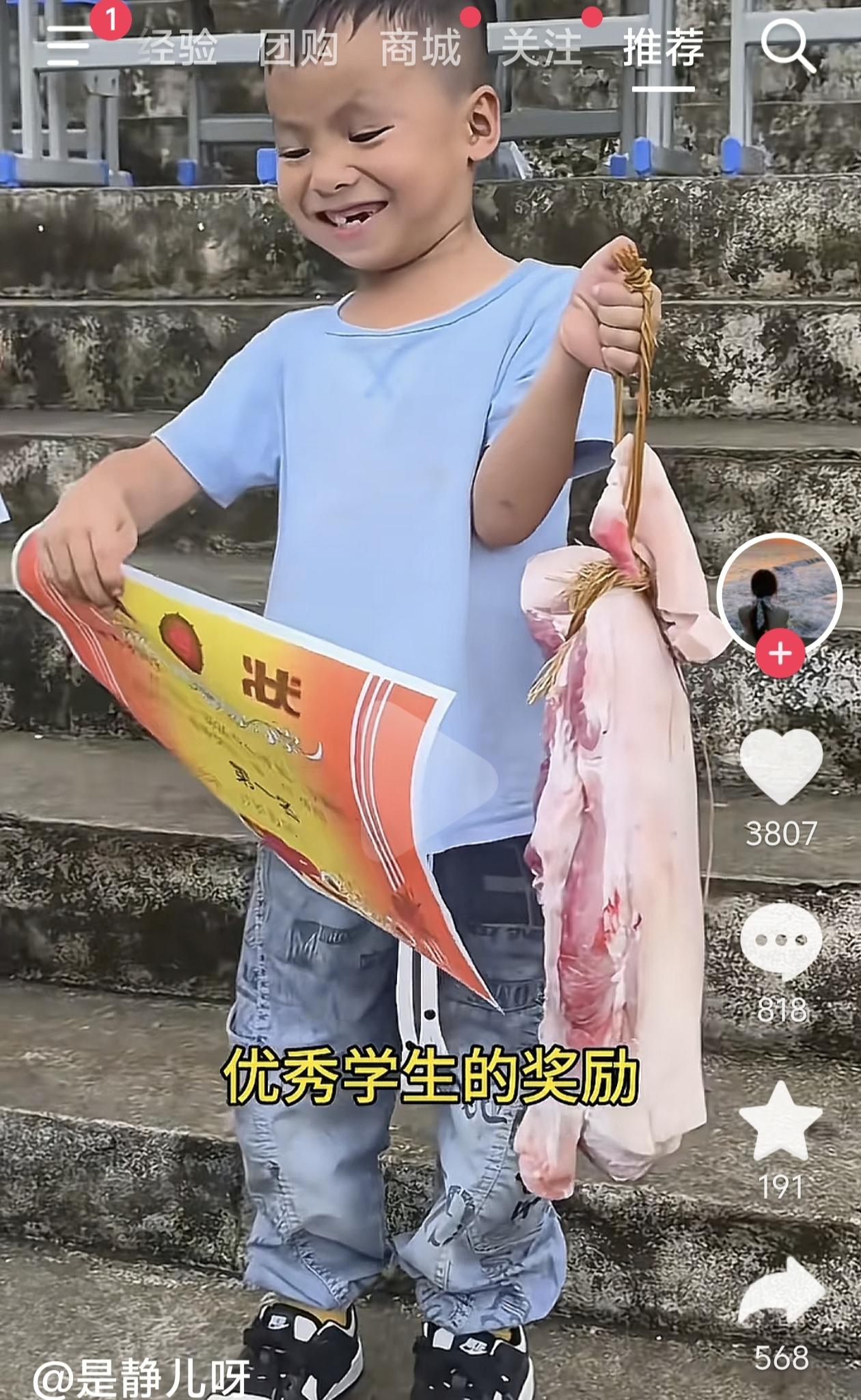 看到这个小男孩一手举着奖状、一手拎着一大块猪肉的视频，心里又欢喜又感动。
这是一