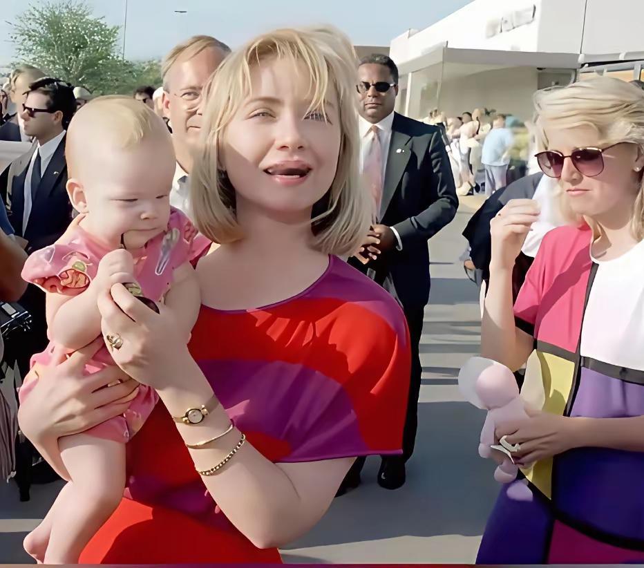 年轻时的希拉里抱着女儿的一张留影，笑容满面展现出初为人母的幸福之情。