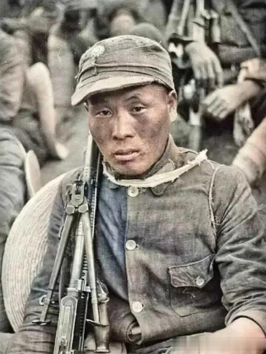 1940年，这是一名年轻的八路军机枪手。他穿着破旧的军装，皮肤黝黑，他的目光警惕