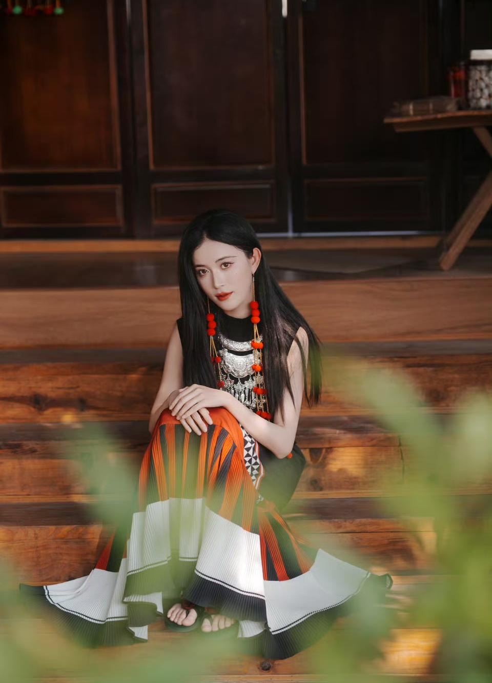 银饰叮咚摇曳，红衣热烈明艳。

古寨木屋间，三角梅开得正好，民族风的独特纹样在裙