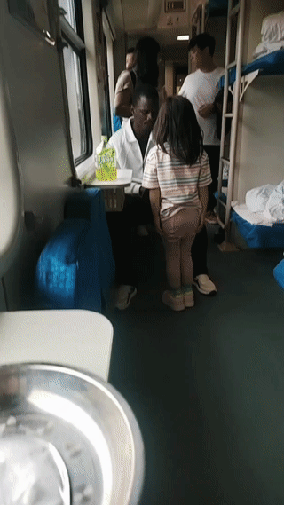 绿皮火车上，一名小女孩竟然站在一个黑人男子身边手舞足蹈，看样子是对黑人男子充满了