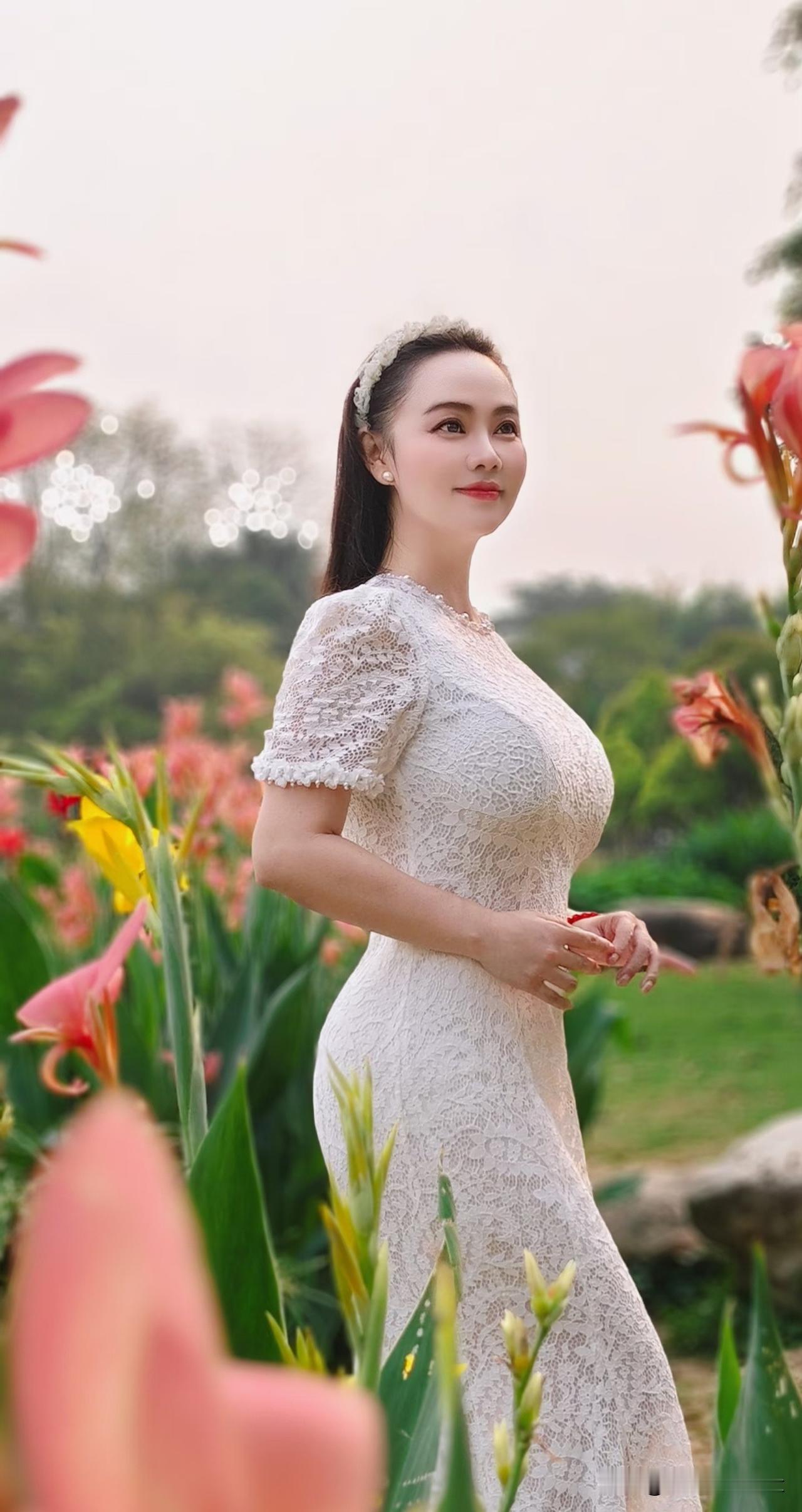 五律·花畔娇娘
 
丽日芳园静，娇姝立艳丛。
罗裙凝素雪，秀目沐和风。
翠叶环身
