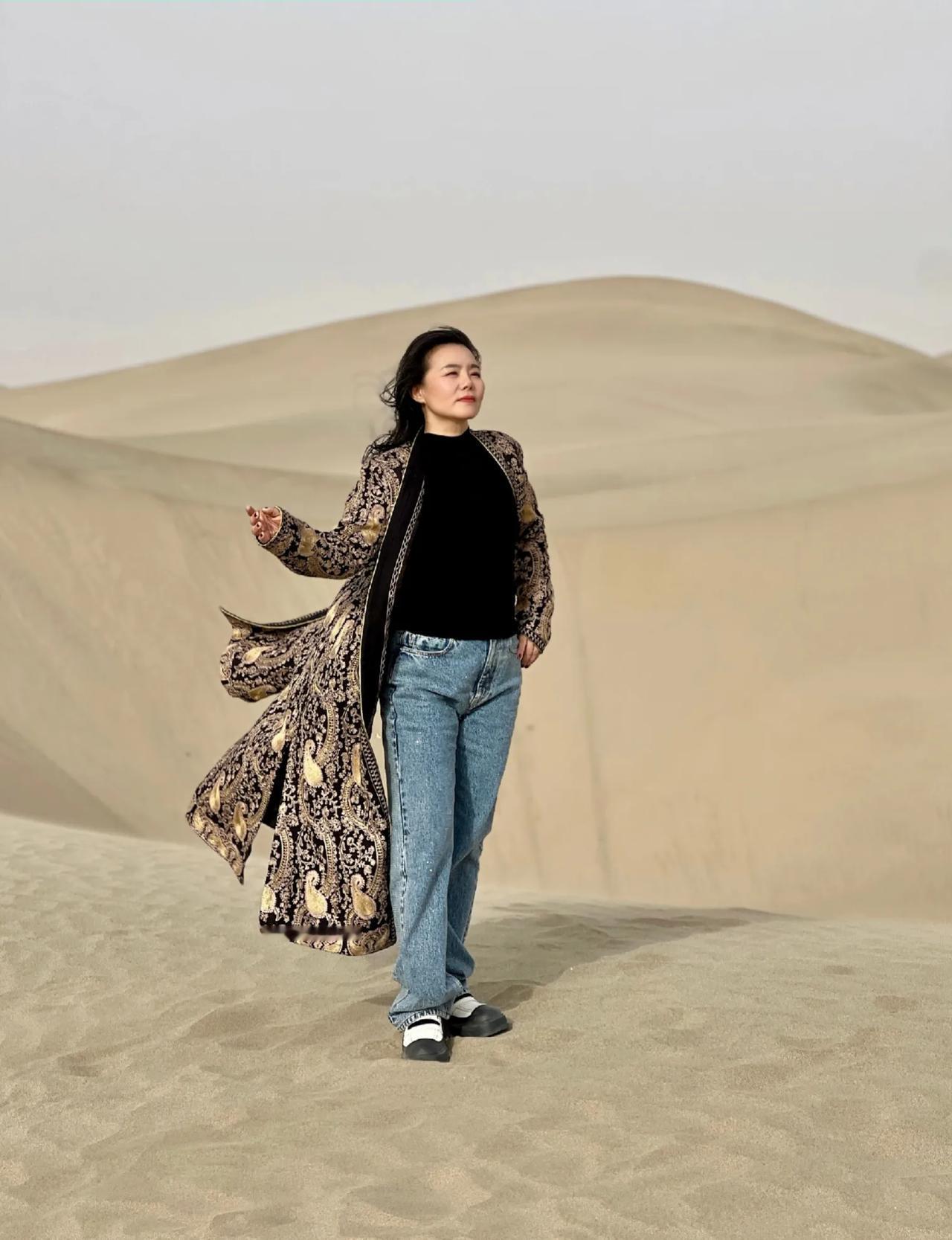 歌唱家龚琳娜现身新疆，坐在沙漠的吉普车里酷飒十足！龚琳娜身穿一件宫廷风长款外套，