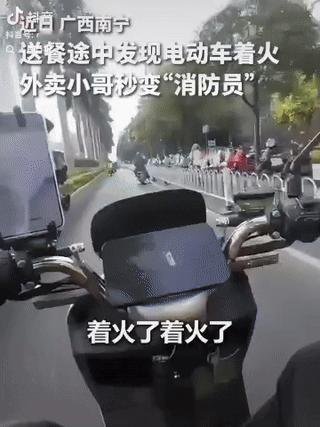“上人民日报了！”一位外卖小哥在送餐途中，看见一路人电动车着火，车主吓得不知所措
