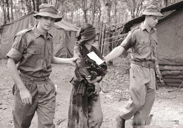 越南战争期间，两名美国大兵将一名越南女游击队员俘虏后，将其五花大绑后，正要把她拖